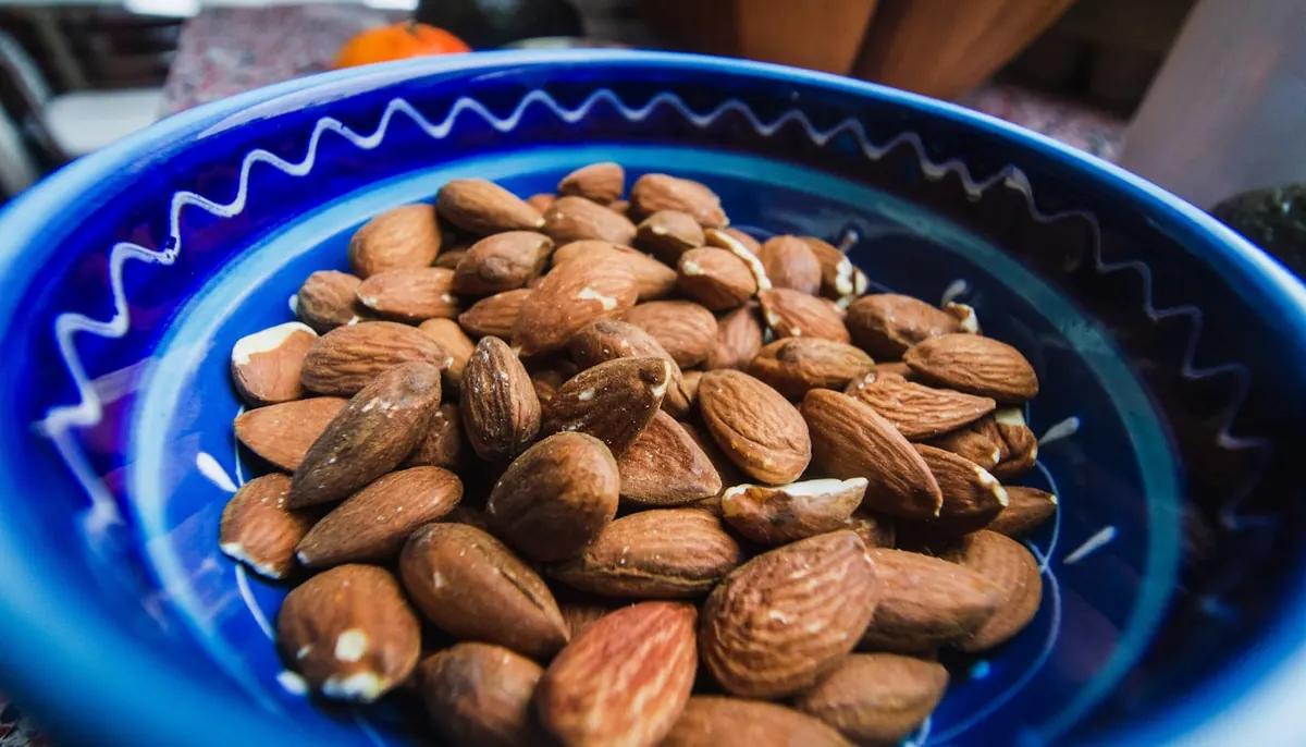 Wholesome bakery ingredients — almonds, Medjool dates, cocoa and cinnamon — on a sunlit kitchen table, the foundation of Natreats healthy baked goods